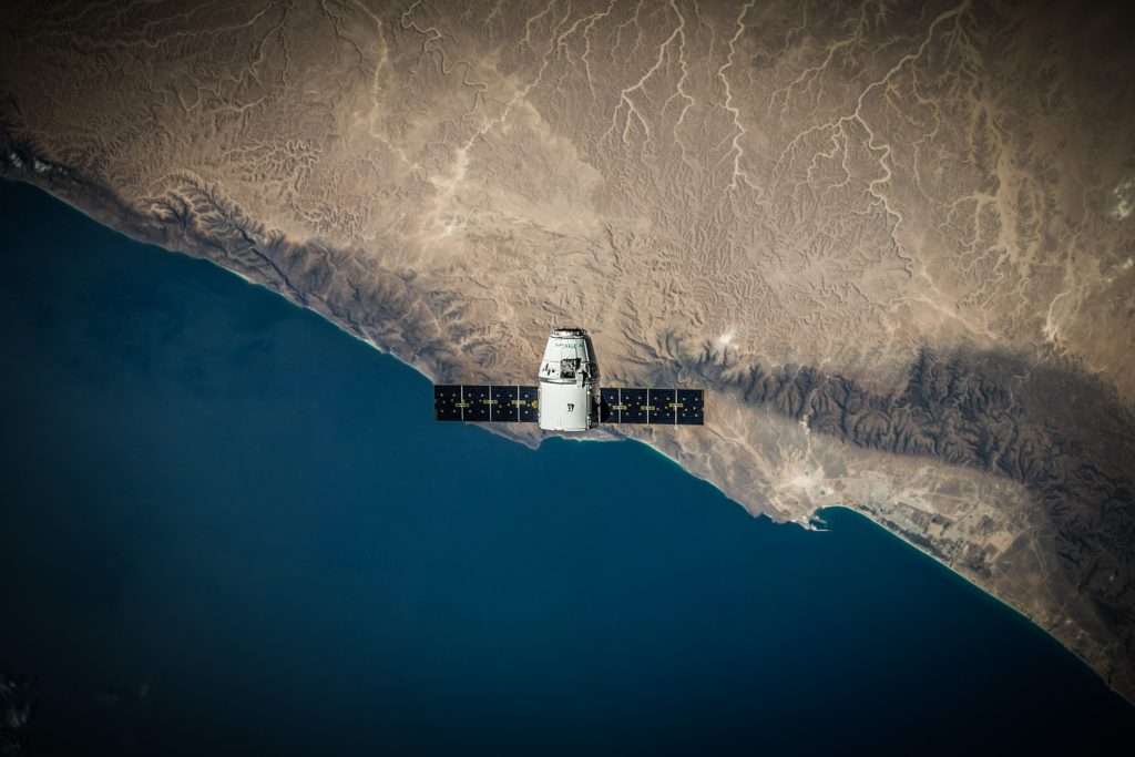 Satélite no centro da imagem sobrevoando a terra